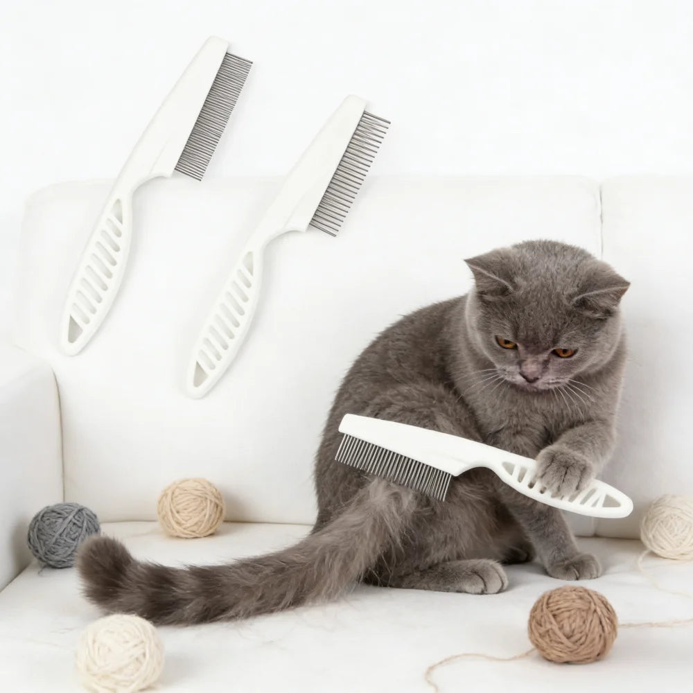 A gray cat is lying on a white surface with a white grooming comb and brush set nearby.